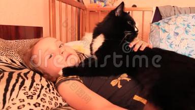 小女孩和她的猫一起躺在床上。 <strong>与你</strong>的宠物一起